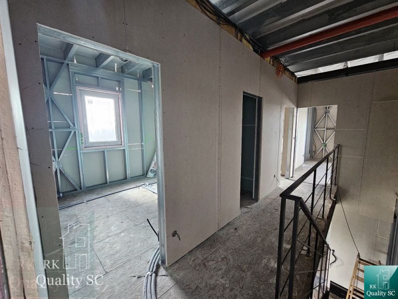 TOMÁŠOV - Okr. Senec -  EXKLUZÍVNE NA PREDAJ NOVOSTAVBA - dva 4 izb. b - Interiér rodinného domu s kovovými rámami a betonovou podlahou.