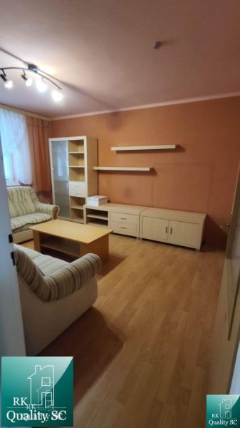 Okres SENEC - obec ČATAJ - NA PREDAJ 4. izbový priestranný mezonetový  - Obývačka s podlahou s dreveným dekorom v 4-izbovom byte, zariadená nábytkom a sedačkou.