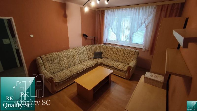 Okres SENEC - obec ČATAJ - NA PREDAJ 4. izbový priestranný mezonetový  - Obývačka v 4-izbovom byte s rohovou sedačkou a podlahou s dreveným dekorom.