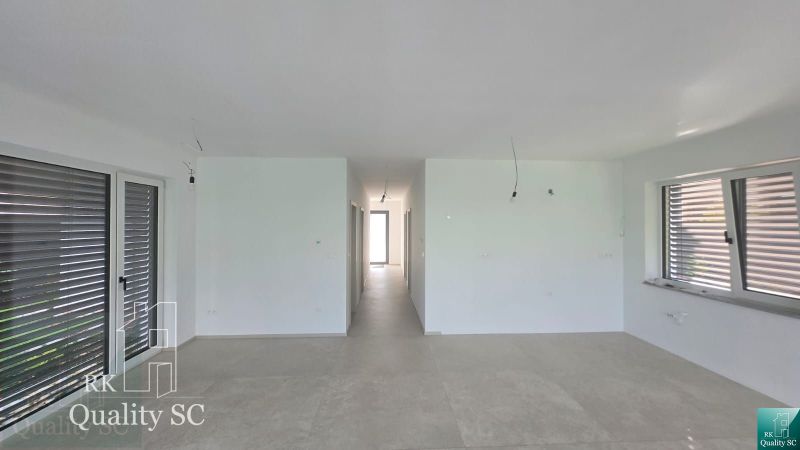 Okr. Senec - Tureň - NA PREDAJ nízkoenergetická novostavba - 4 izbový  - Interiér rodinného domu so svetlými stenami, dlažbou a veľkými oknami.