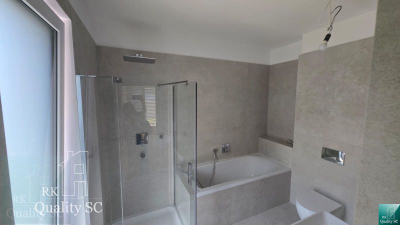 Okr. Senec - Tureň - NA PREDAJ nízkoenergetická novostavba - 4 izbový  - Kúpeľňa s vaňou a sprchou v rodinnom dome, s elegantnými béžovými obkladmi.