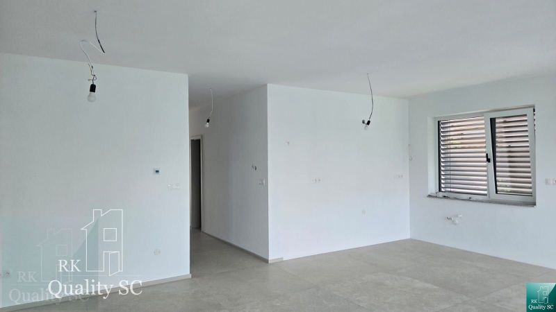 Okr. Senec - Tureň - NA PREDAJ nízkoenergetická novostavba - 4 izbový  - Interiér rodinného domu s bielymi stenami, veľkým oknom a podlahou s dreveným dekorom.