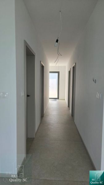 Okr. Senec - Tureň - NA PREDAJ nízkoenergetická novostavba - 4 izbový  - Chodba v rodinnom dome s dlažbou a dverami po stranách.