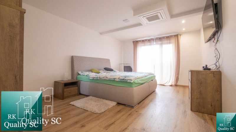 STÁLE NOVÁ CENA - SENEC SLNEČNÉ JAZERÁ JUH – NA PREDAJ – novostavba re - Svetlá spálňa v rodinnom dome s posteľou a podlahou s dreveným dekorom.