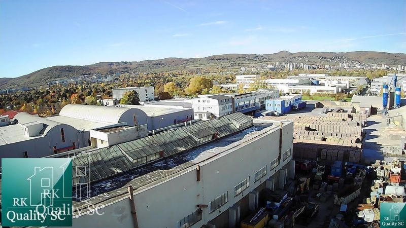 BRATISLAVA III. - RAČA - NA PREDAJ - priemyselný objekt s polyfunkčnou - Výhľad na obchodné priestory v Bratislave III na Staviteľskej ulici s okolitými kopcami.