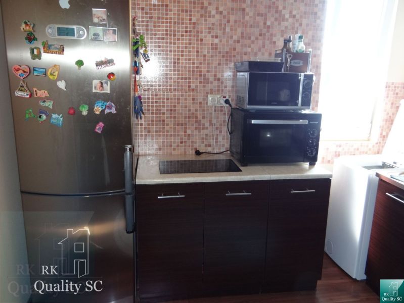 REZERVOVANÉ - 2 izbový veľký celoročne obývateľný apartmán s terasou,  - Kuchyňa v 2-izbovom byte so sporákom a chladničkou, podlaha s dreveným dekorom.