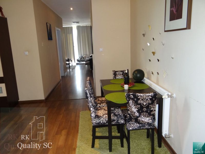 REZERVOVANÉ - 2 izbový veľký celoročne obývateľný apartmán s terasou,  - Jedálenský stôl so stoličkami, podlaha s dreveným dekorom, 2-izbový byt, chodba, závesy.
