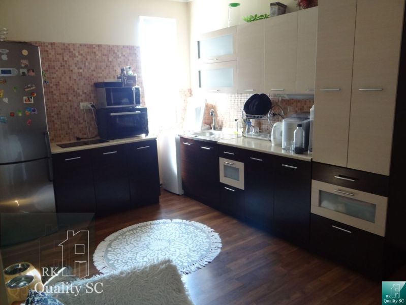 REZERVOVANÉ - 2 izbový veľký celoročne obývateľný apartmán s terasou,  - Kuchyňa v 2-izbovom byte s kuchynskými spotrebičmi a podlahou s dreveným dekorom.