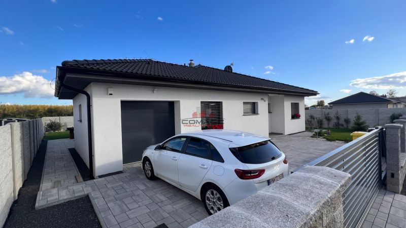 4 iz bungalov s terasou v Piešťanoch a okolí - STAVIAME - Rodinný dom na Fínskej ulici v Piešťanoch so zaparkovaným autom na spevnenej ploche.