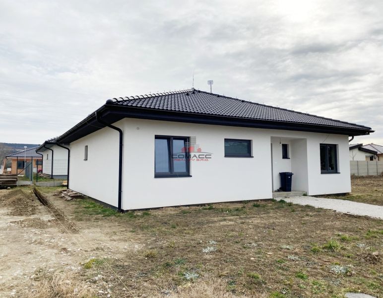 4 iz bungalov s terasou v Piešťanoch a okolí - STAVIAME - Biely rodinný dom na Fínskej ulici v Piešťanoch s okolitou zeleňou a oblohou.