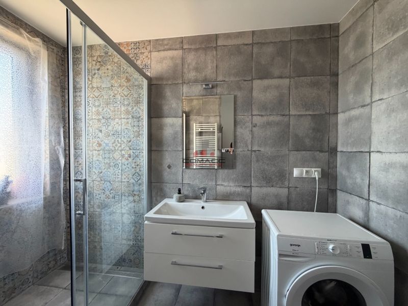 Ex. Moderný 3 iz. byt 90 m2 s garážou a záhradou v Dolnom Trhovišti - Kúpeľňa s kachličkami, sprchovacím kútom, umývadlom a práčkou v 3-izbovom byte.