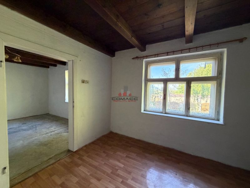 Exkl. 3 izbový rodinný dom v H. Orešanoch ZĽAVA - Interiér rodinného domu s podlahou s dreveným dekorom a veľkým oknom.