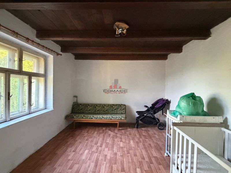 Exkl. 3 izbový rodinný dom v H. Orešanoch ZĽAVA - Miestnosť v rodinnom dome s dreveným stropom, sedačkou a podlahou s dreveným dekorom.