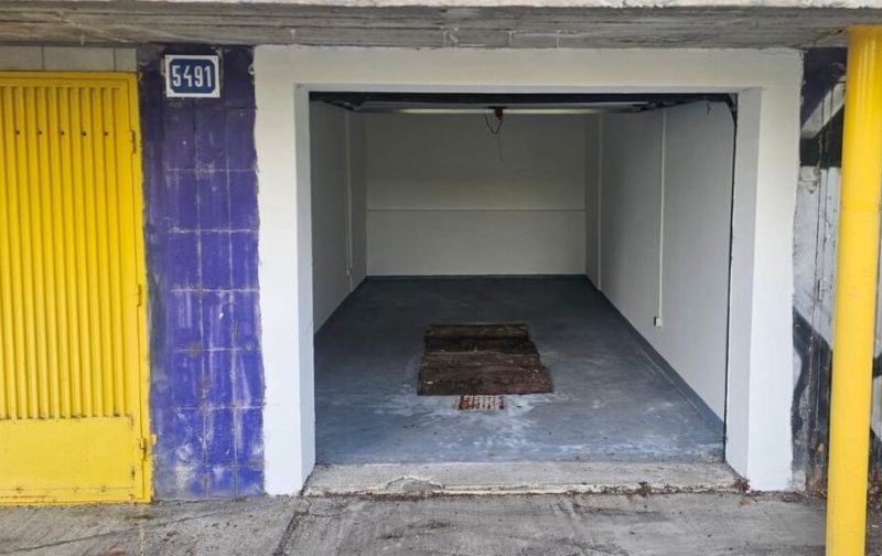 Garáž na Karloveskej ulici  - Otvorená garáž na Karloveskej ulici v Bratislave, Karlova Ves, s betónovou podlahou.