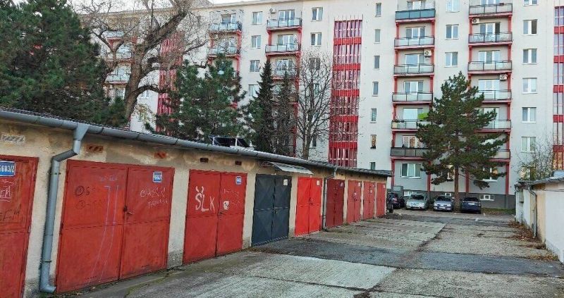 Predaj - Garáž na Haburskej ulici pri Štrkovci - Garáže na Haburskej ulici v Bratislave - Ružinove pred bytovým domom s balkónmi a stromami.