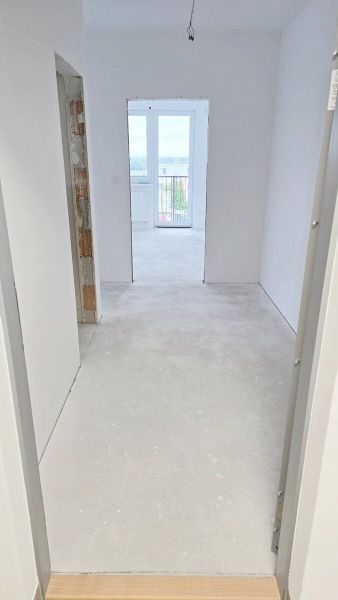 Novostavba - 3- izb. byt s 2 balkónmi a garáž. na ul. Jána Ondruša - Chodba v 3-izbovom byte s bielymi stenami a výhľadom na balkón.
