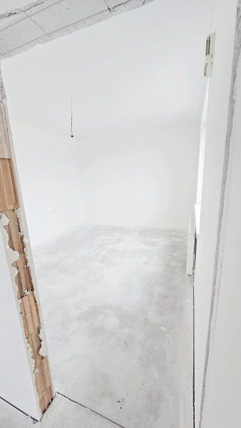 Novostavba - 3- izb. byt s 2 balkónmi a garáž. na ul. Jána Ondruša - Prázdna miestnosť v 3-izbovom byte s bielymi stenami a betónovou podlahou.