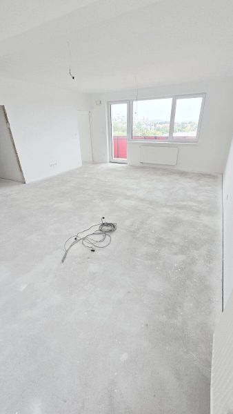 Novostavba - 3- izb. byt s 2 balkónmi a garáž. na ul. Jána Ondruša - Svetlá izba s veľkým oknom a nedokončenou podlahou v 3-izbovom byte.
