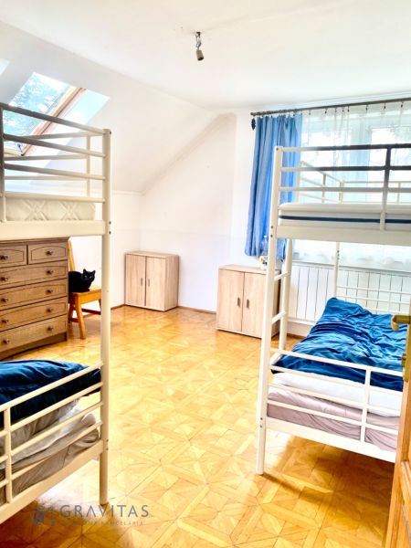 Rekreačný RD pri Oravskej Priehrade na Slanickej Osade - Izba so štyrmi posteľami, bielym nábytkom a modrými závesmi, vhodná pre rodinný dom.