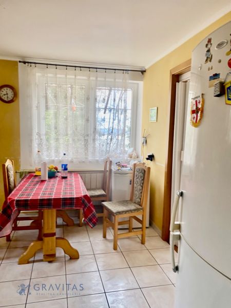 Rekreačný RD pri Oravskej Priehrade na Slanickej Osade - Kuchyňa v rodinnom dome so zariadením, dreveným stolom a chladničkou.