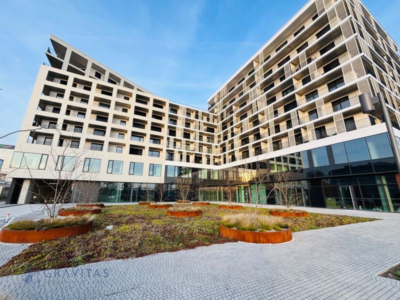 Na PREDAJ | 4izb. veľkometrážny ateliér | Prístavná ulica - Budova s modernou architektúrou na Prístavnej v Bratislave - Ružinove, obklopená zeleňou.