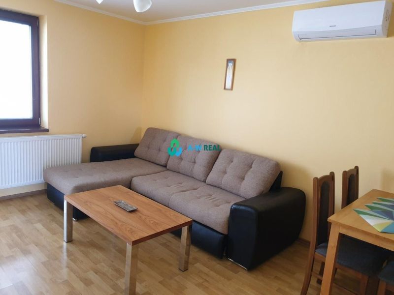 Apartmánový dom na predaj blízko termálneho kúpaliska - Obývacia izba s pohovkou, stolíkom a podlahou s dreveným dekorom v hoteli a penzióne.