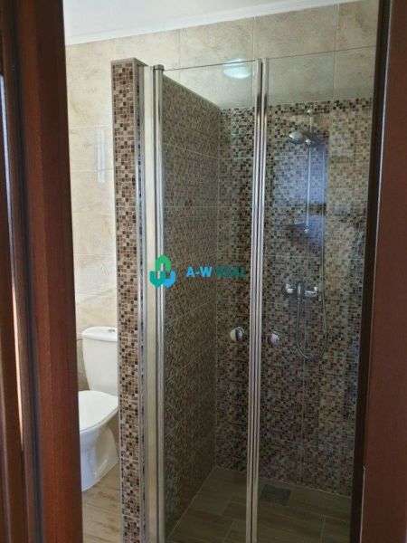 Apartmánový dom na predaj blízko termálneho kúpaliska - Kúpeľňa s toaletou, sprchovým kútom s mozaikovým obkladom a podlahou s dreveným dekorom.