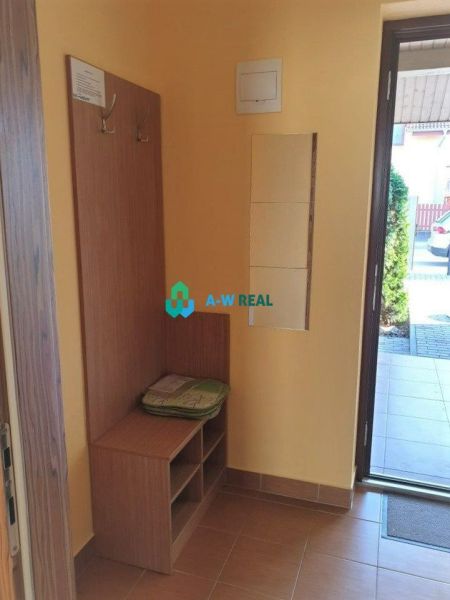 Apartmánový dom na predaj blízko termálneho kúpaliska - Vstupná hala v Hotely a penzióny s botníkom a vešiakmi, podlaha s dreveným dekorom.