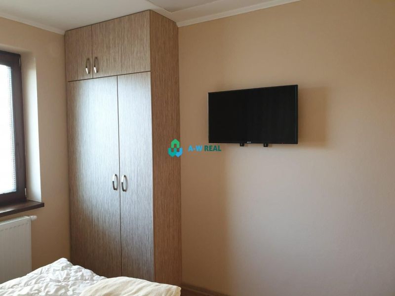 Apartmánový dom na predaj blízko termálneho kúpaliska - Šatníková skriňa, televízor na stene a posteľ v hoteli a penzióne.