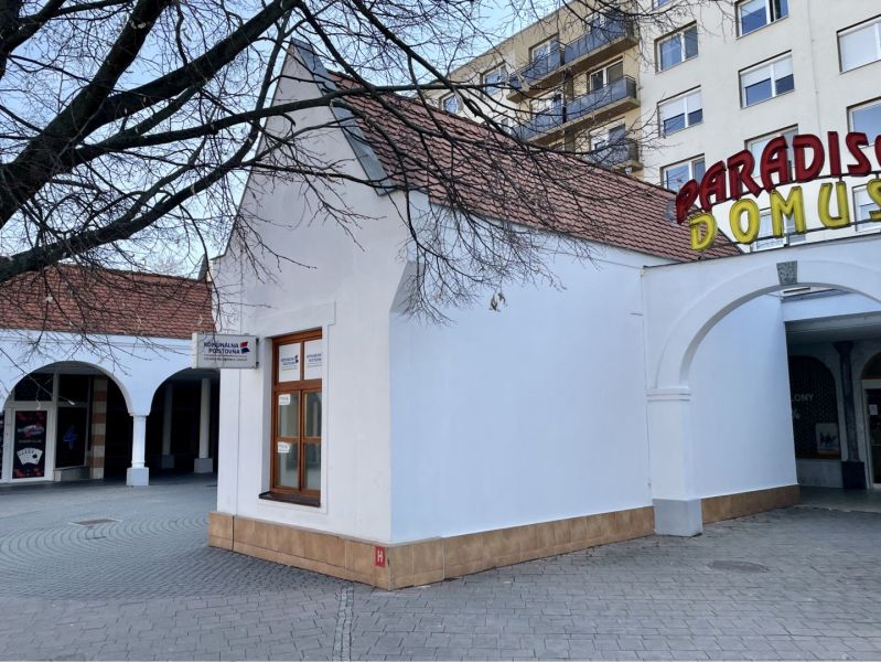 DUNASJKÁ STREDA – OBCHODNÝ/ADMINISTRATÍVNY PRIESTOR PRIAMO V CENTRE ME - Obchodné priestory na Námestí Ármina Vámbéryho v Dunajskej Strede s bielou fasádou a oblúkovou arkádou.
