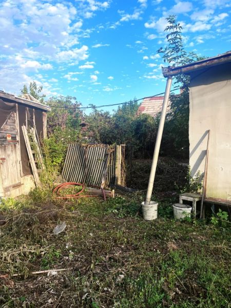 JAHODNÁ – STARÝ RODINNÝ DOM S PEKNÝM STAVEBNÝM POZEMKOM NA PREDAJ - Záhrada za rodinným domom v Jahodnej s roztrhanými plechmi a bujnou vegetáciou.