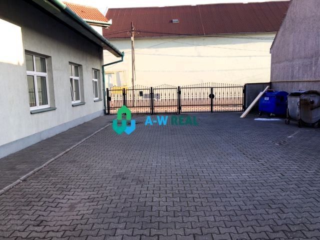 Predádzkový objekt na prenájom v centre mesta - Dvor v obchodných priestoroch Dunajskej Stredy s bránou a smetnými nádobami.