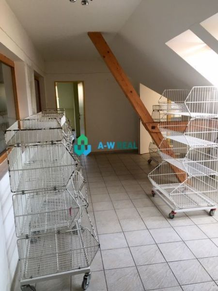 Predádzkový objekt na prenájom v centre mesta - Svetlé obchodné priestory s klietkami na dlažbe a šikmým stropom.