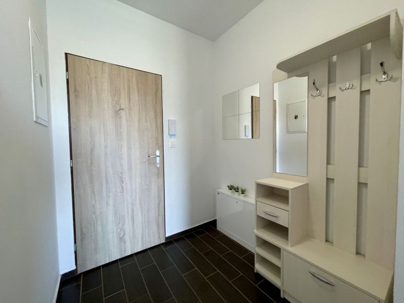 2-IZBOVÝ BYT S VEĽKÝM BALKÓNOM NA PREDAJ - Vstupná chodba v 2-izbovom byte s dlažbovou podlahou a nástennými vešiakmi.