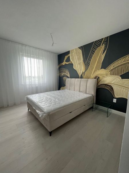Luxusný byt na prenájom úplne nový kompletne zariadený s garážou. - Spálňa v 3-izbovom byte s dekoratívnou stenou a podlahou s dreveným dekorom.