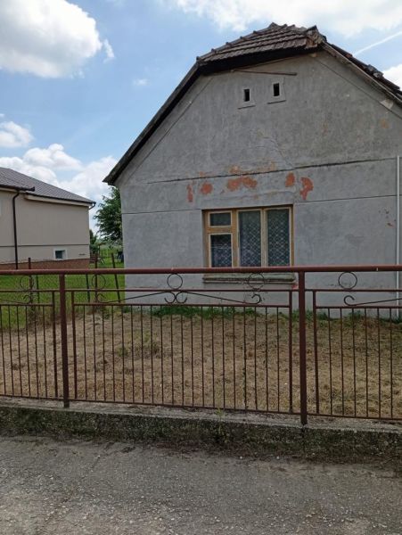 Vidiecky domček na predaj. - Rodinný dom v Ňáradi so staršou fasádou a kovovým plotom.
