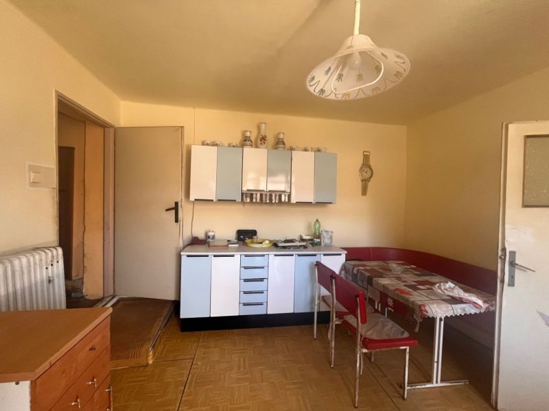 Rodinný dom okamžite obývateľný. - Kuchyňa s retro nábytkom a podlahou s dreveným dekorom v rodinnom dome.