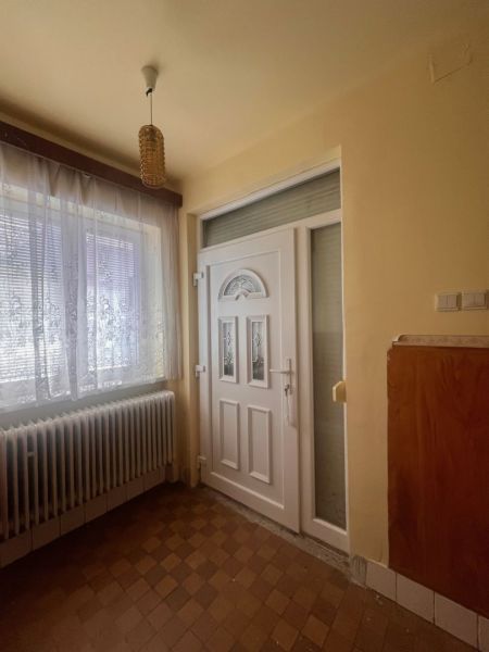 Rodinný dom okamžite obývateľný. - Vstupná hala so svetelným lustrom a radiátorom v rodinnom dome.