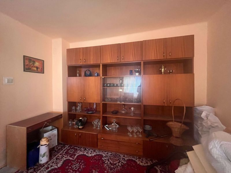 Rodinný dom okamžite obývateľný. - Obývačka v rodinnom dome so starším nábytkom a vitrínou na koberci.