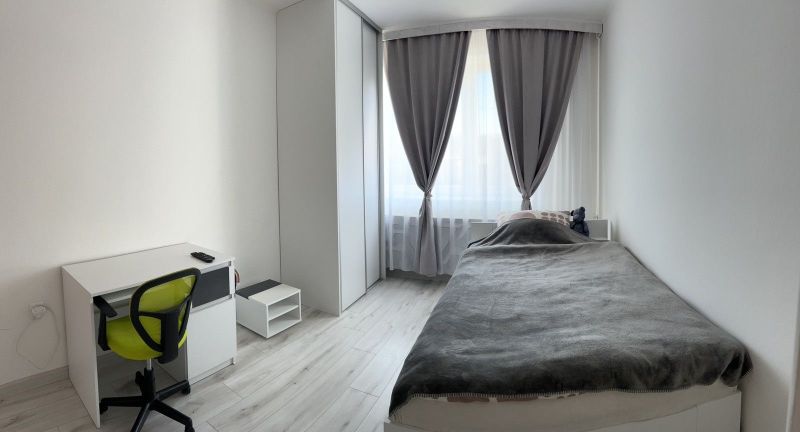 Ůžasný rodinný dom v obci Trstice. - Minimalistická spálňa v rodinnom dome s písacím stolom a podlahou s dreveným dekorom.