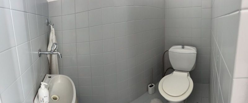 Ůžasný rodinný dom v obci Trstice. - Kúpeľňa s bielymi dlaždicami, umývadlom a toaletou v rodinnom dome.