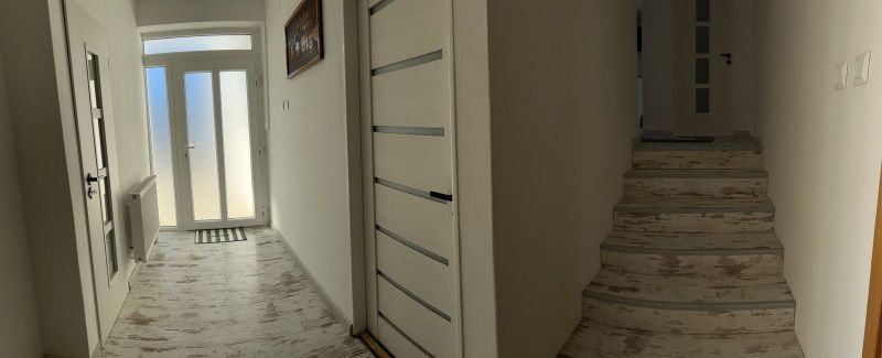 Ůžasný rodinný dom v obci Trstice. - Interiér rodinného domu s chodbou, schodiskom a podlahou s dreveným dekorom.