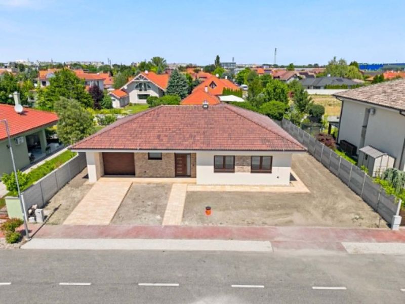 Moderný 4-izbový rodinný dom s garážou  v TOP lokalite pri termálnom k - Rodinný dom v Dunajskej Strede s červenou strechou a spevnenou príjazdovou cestou.