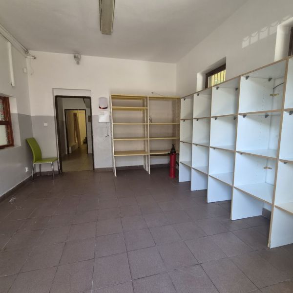 Na prenájom polyfunkčný objekt v DS - Interiér miestnosti s policami, stoličkou a hasiacim prístrojom, v budove.