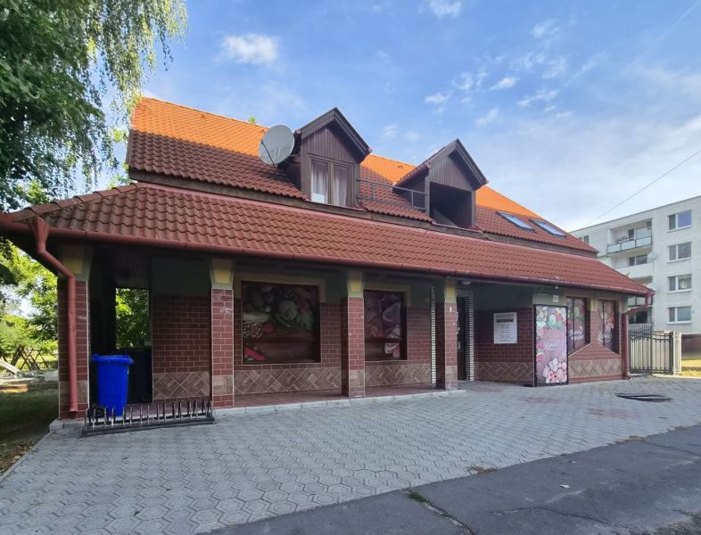 Na prenájom polyfunkčný objekt v DS - Budova v Dunajskej Strede s červenou strechou a tehlovým obkladom.