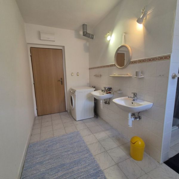 Prenájom 2-izbového apartmánu v Dunajskej Strede - Kúpeľňa s dvomi umývadlami v 2-izbovom byte, práčka a svetlé obklady.
