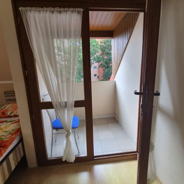 Prenájom 2-izbového apartmánu v Dunajskej Strede - Dvojizbový byt s balkónom, záclonou a podlahou s dreveným dekorom.