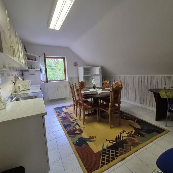 Prenájom 2-izbového apartmánu v Dunajskej Strede - Kuchyňa v 2-izbovom byte s jedálenským stolom a farebným kobercom na podlahe.