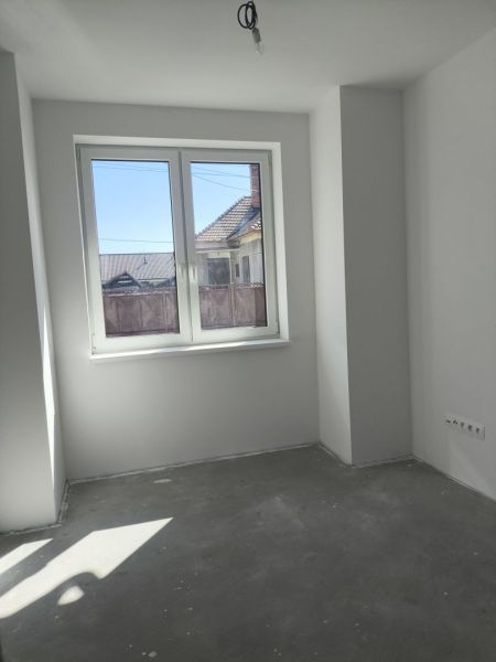 Moderný 4-izbový rodinný dom (dvojdom) v obci Vrakúň - Prázdna miestnosť s betónovou podlahou a veľkým oknom v rodinnom dome.