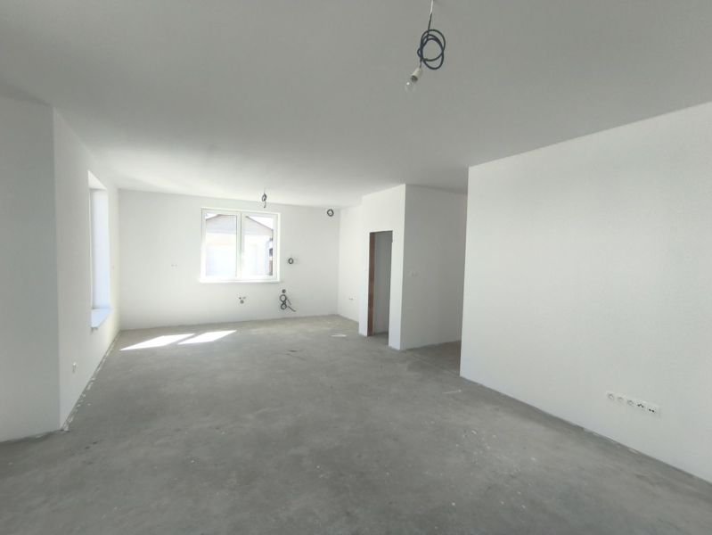 Moderný 4-izbový rodinný dom (dvojdom) v obci Vrakúň - Priestranná miestnosť v rodinnom dome s betónovou podlahou a bielymi stenami.